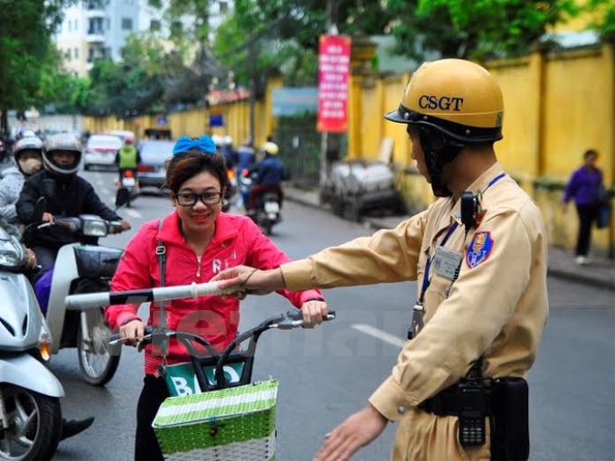 Nhiều học sinh vẫn bất ngờ khi bị xử phạt lỗi không đội mũ bảo hiểm khi điều khiển xe đạp điện (Ảnh: Võ Phương/Vietnam+)